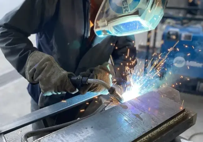 Fabrication worker welding a piece of metal