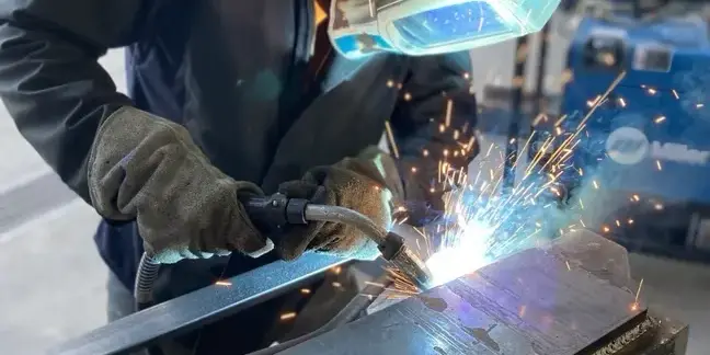 Fabrication worker welding a piece of metal